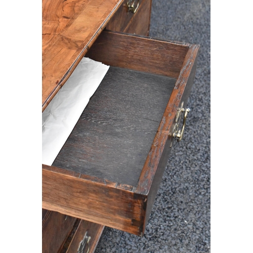 152 - A circa 1700 walnut chest of drawers, having a quarter cut veneered and cross banded top, two short ... 