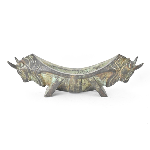 179 - A 20th century Chinese patinated bronzed oblong shaped bowl, the sides fashioned as two bulls heads ... 