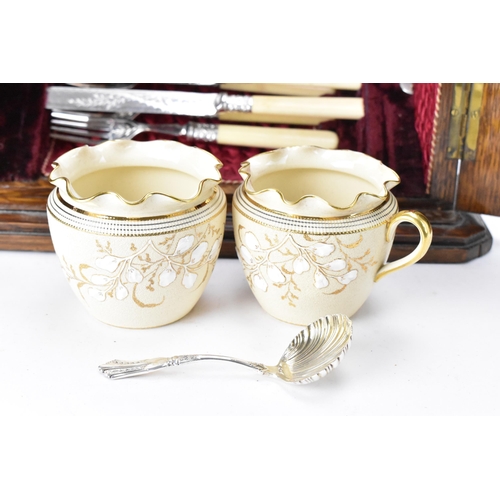 198 - A late Victorian oak cased silver plated dessert canteen, consisting of two berry spoons, grape scis... 