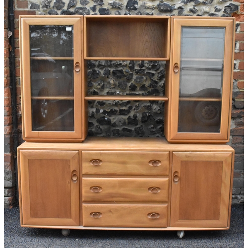 199 - An Ercol Windsor range light elm display cabinet, having three open shelves flanked by two glazed do... 