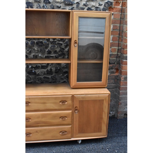 199 - An Ercol Windsor range light elm display cabinet, having three open shelves flanked by two glazed do... 