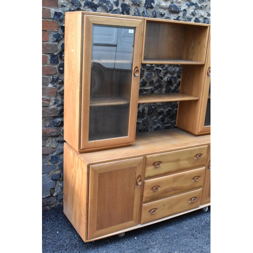 199 - An Ercol Windsor range light elm display cabinet, having three open shelves flanked by two glazed do... 