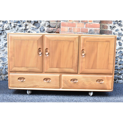 203 - A mid 20th century Ercol Windsor range light elm sideboard, mode 468, having three cupboard doors ab... 