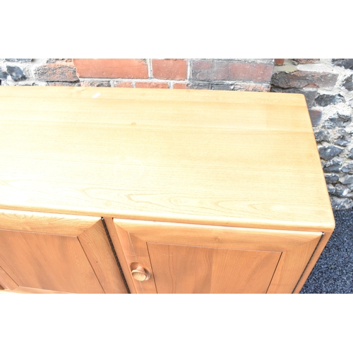 203 - A mid 20th century Ercol Windsor range light elm sideboard, mode 468, having three cupboard doors ab... 