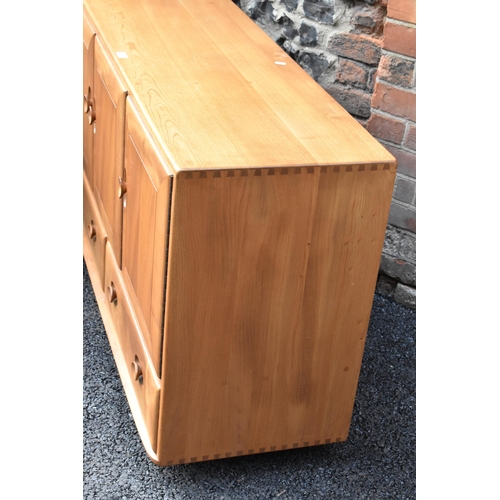 203 - A mid 20th century Ercol Windsor range light elm sideboard, mode 468, having three cupboard doors ab... 