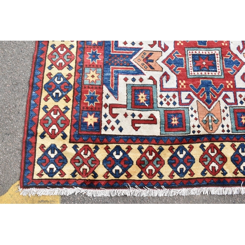 228 - A handwoven Caucasian star kazak rug, having a geometric designs with repeating motifs, multiguard b... 