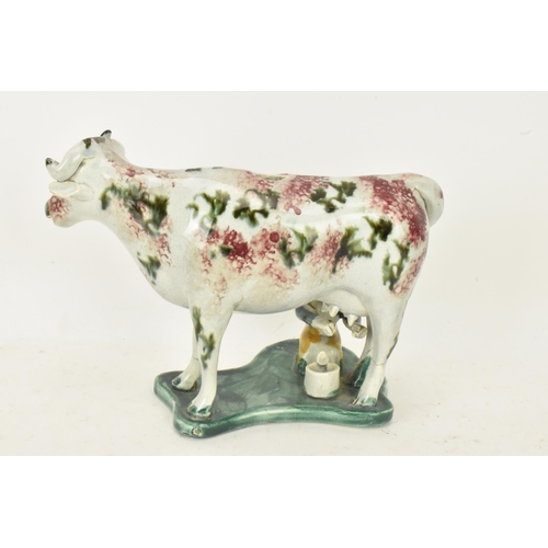 248 - Two early 19th century pearlware pink and green sponge decorated cow creamers with milkmaids, possib... 