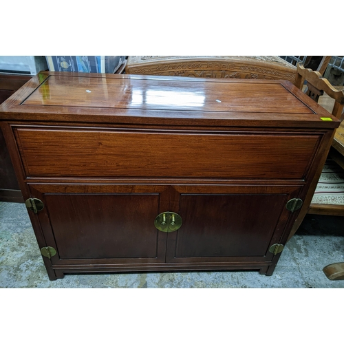 420 - A Chinese rosewood side cabinet with hinged top, twin cupboard doors revealing a fitted partitioned ... 