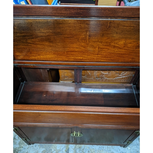 420 - A Chinese rosewood side cabinet with hinged top, twin cupboard doors revealing a fitted partitioned ... 