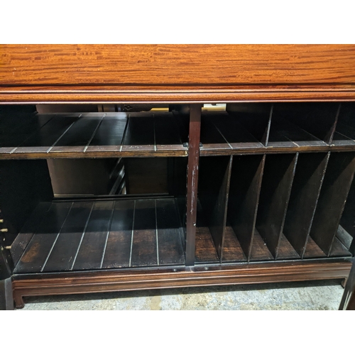 420 - A Chinese rosewood side cabinet with hinged top, twin cupboard doors revealing a fitted partitioned ... 