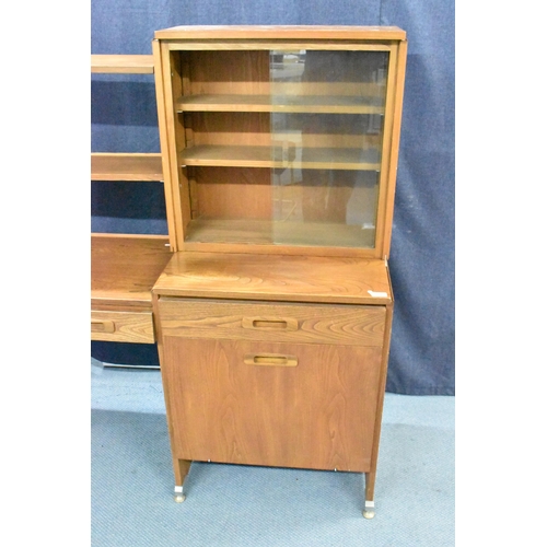 457 - A 1960s light elm desk, having a glazed section with two sliding doors and open shelves, above drawe... 