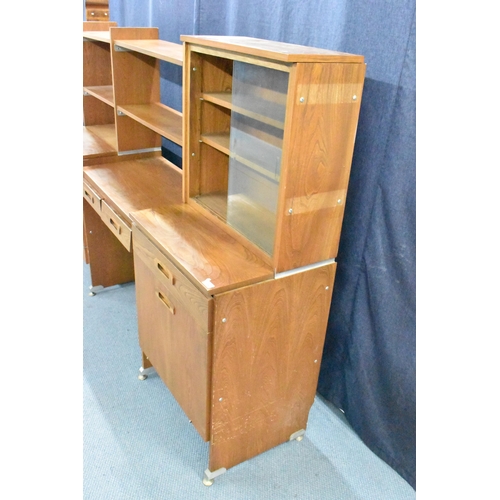 457 - A 1960s light elm desk, having a glazed section with two sliding doors and open shelves, above drawe... 