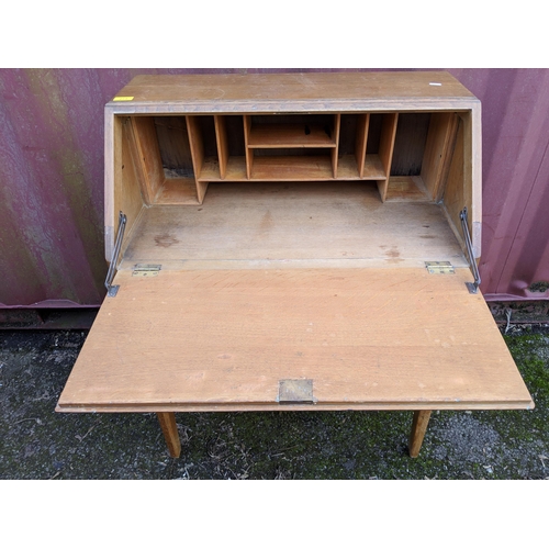 445 - A modern light oak bureau with a fall flap over two drawers, raised on straight legs, 101h x 76w, a ... 