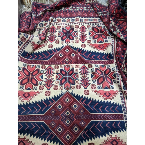 462 - A Turkish Kazakh woollen hand woven carpet in reds, blue and ivory colours, all over geometric and f... 