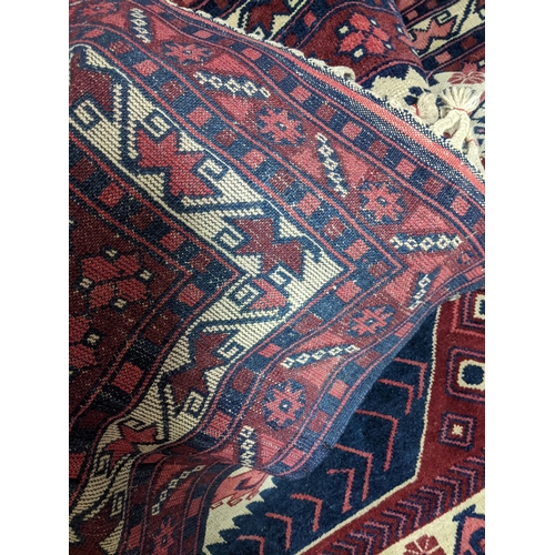 462 - A Turkish Kazakh woollen hand woven carpet in reds, blue and ivory colours, all over geometric and f... 