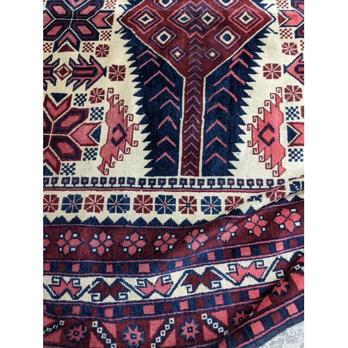 462 - A Turkish Kazakh woollen hand woven carpet in reds, blue and ivory colours, all over geometric and f... 