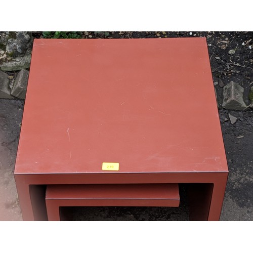 509 - A modern metal framed table with a glass top and a matching lamp table, a red modernist style lamp t... 