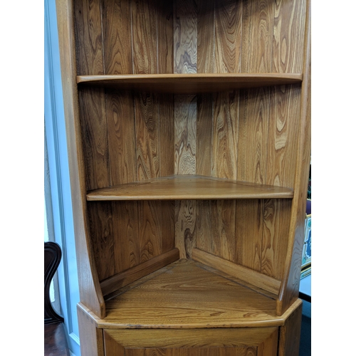 233 - A blonde Ercol corner unit with two shelves over a cupboard raised on a plinth Location: LAB