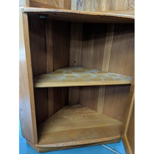 233 - A blonde Ercol corner unit with two shelves over a cupboard raised on a plinth Location: LAB