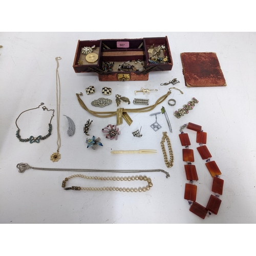 507 - A selection of costume jewellery to include an agate necklace, various brooches and other items, hou... 