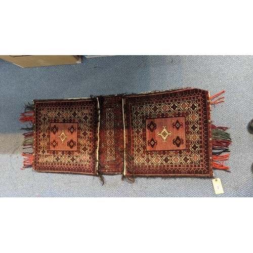 460 - A Persian saddle bag rug having geometric motifs on a red ground 49cm w x 125cm l
Location:G