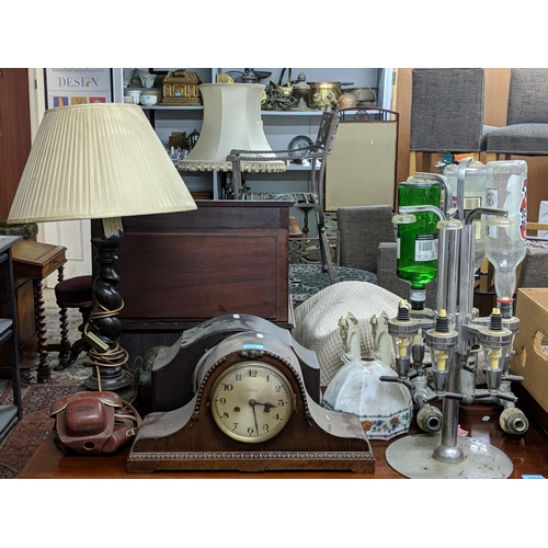 106 - A mixed lot to include a plated drinks dispenser stand, two mantel clocks, a barley twist table lamp... 
