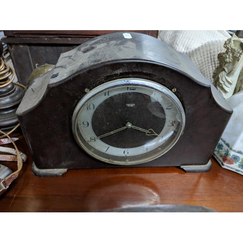 106 - A mixed lot to include a plated drinks dispenser stand, two mantel clocks, a barley twist table lamp... 