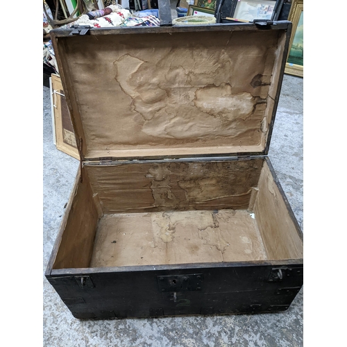 107 - A 19th century wooden travelling chest with iron bound straps and carrying handles 55cm x 94cm x 59c... 