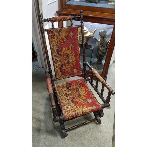 86 - A late 19th century American walnut finished rocking chair with a carpet back and seatLocation: G