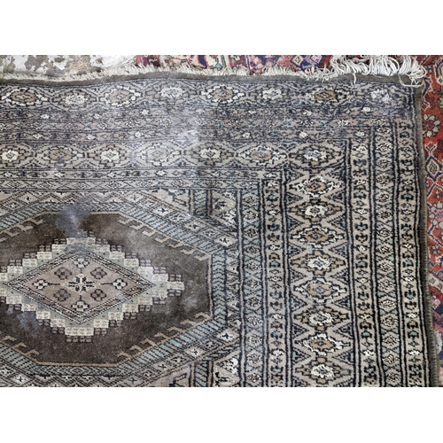 103 - A Middle Eastern handwoven green ground rug having two vertical rows of seven elephant gulls, multig... 