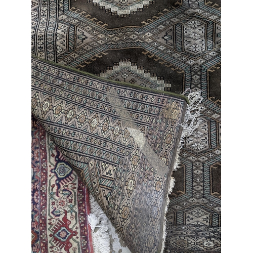 103 - A Middle Eastern handwoven green ground rug having two vertical rows of seven elephant gulls, multig... 