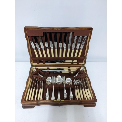 115 - A mahogany veneered cased Arthur Price canteen of silver plated cutlery set with stimulated ivory ha... 