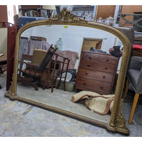 93 - Victorian gilt framed overmantel mirror surmounted with scrolled and stylized leaf decoration enclos... 