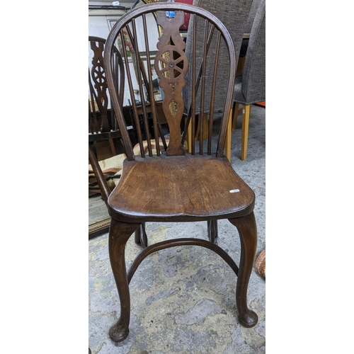 96 - Two 20th century elm seated Windsor wheel back chairs with crinoline elliptical and stretchers, cabr... 