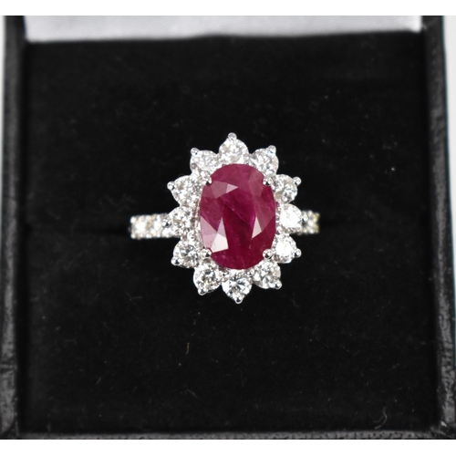 154 - An 18ct white gold, diamond and ruby dress ring, set with central oval mixed cut ruby in four claw s... 