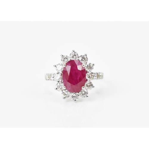 154 - An 18ct white gold, diamond and ruby dress ring, set with central oval mixed cut ruby in four claw s... 