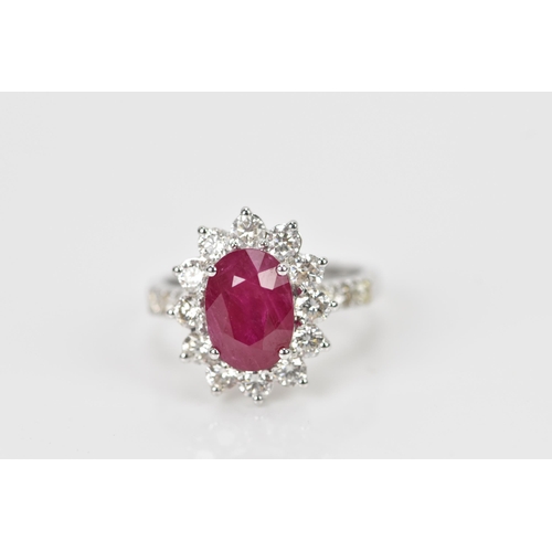 154 - An 18ct white gold, diamond and ruby dress ring, set with central oval mixed cut ruby in four claw s... 