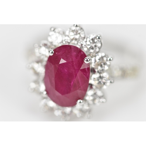 154 - An 18ct white gold, diamond and ruby dress ring, set with central oval mixed cut ruby in four claw s... 