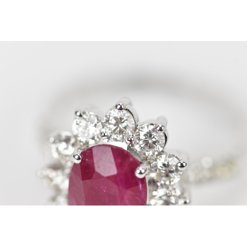 154 - An 18ct white gold, diamond and ruby dress ring, set with central oval mixed cut ruby in four claw s... 