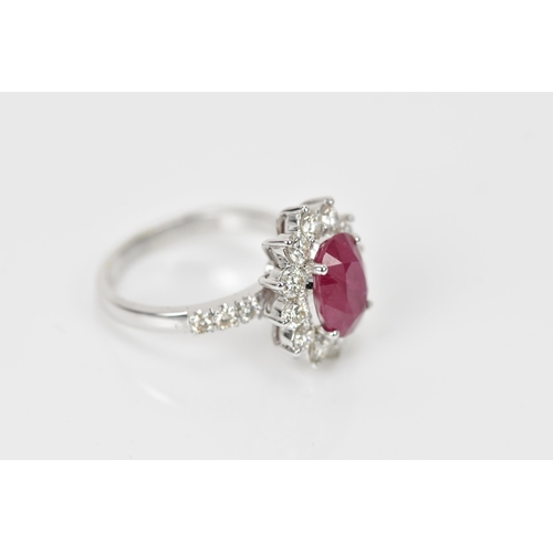 154 - An 18ct white gold, diamond and ruby dress ring, set with central oval mixed cut ruby in four claw s... 