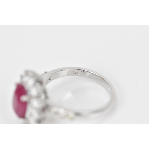 154 - An 18ct white gold, diamond and ruby dress ring, set with central oval mixed cut ruby in four claw s... 