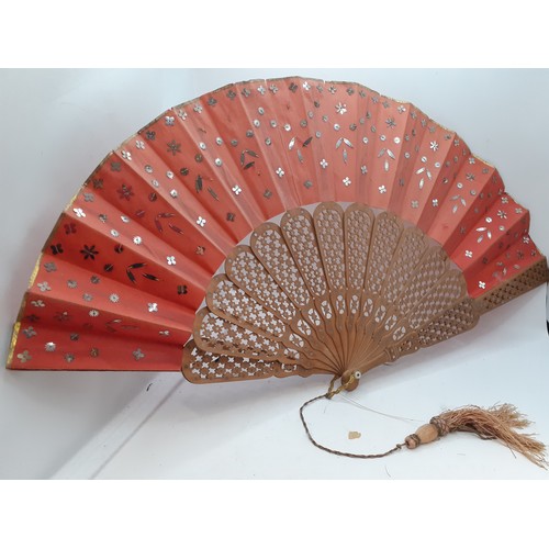 136 - Three Continental fans to include a Victorian treen and paper cockade fan with inset mirror. Locatio... 