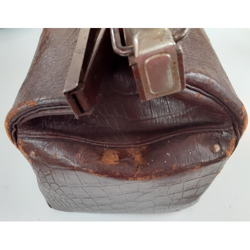 142 - An early 20th Century brown leather Gladstone bag A/F having a crocodile design with brushed silver ... 