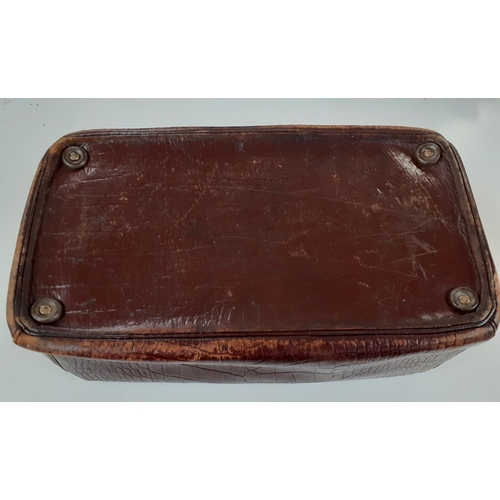 142 - An early 20th Century brown leather Gladstone bag A/F having a crocodile design with brushed silver ... 