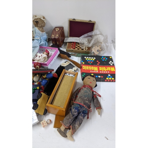 250 - A mixed lot to include playing cards, boxed miniature chess set, dolls and other various toys and ga... 