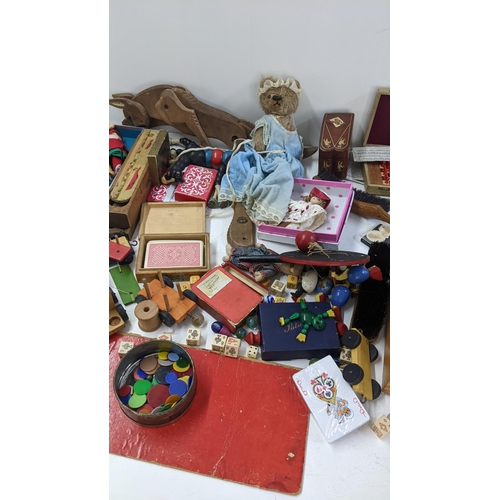 250 - A mixed lot to include playing cards, boxed miniature chess set, dolls and other various toys and ga... 