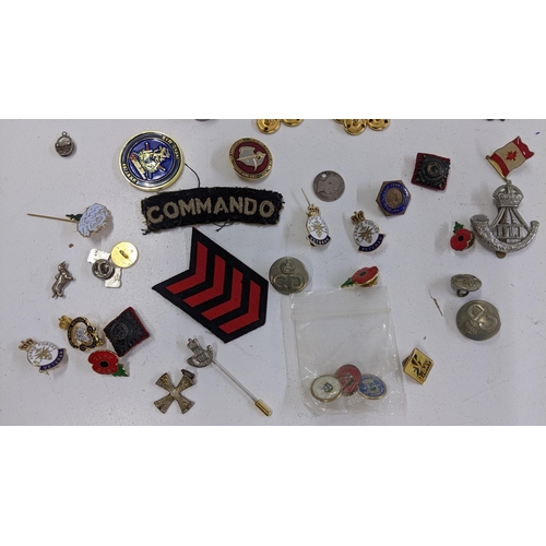 245 - A mixed lot of mainly badges to include a Durham Light Infantry cap badge, and others, together with... 