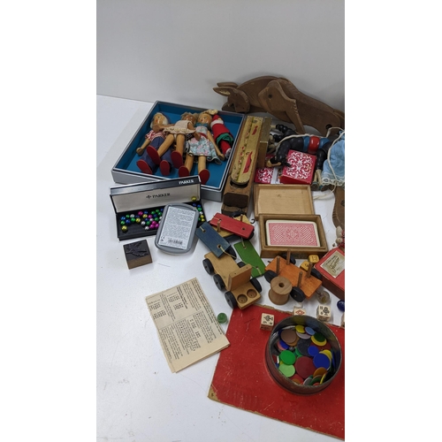 250 - A mixed lot to include playing cards, boxed miniature chess set, dolls and other various toys and ga... 