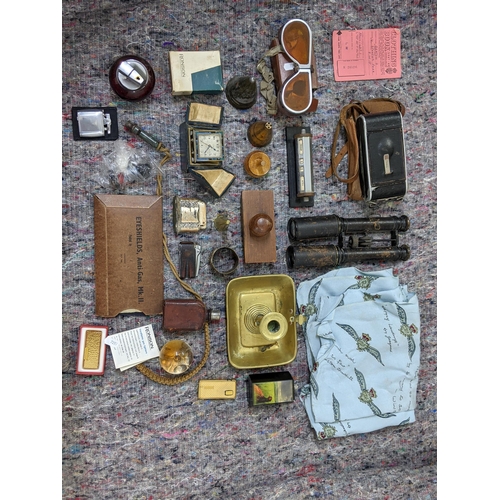 280 - A mixed lot consisting of binoculars, lighters, a mid century desk calendar, a brass candle/chamber ... 