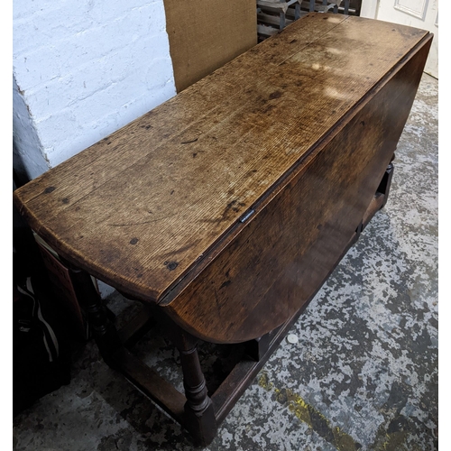 300 - An early 18th century oak drop leaf dining table on turned block legs Location: BWR